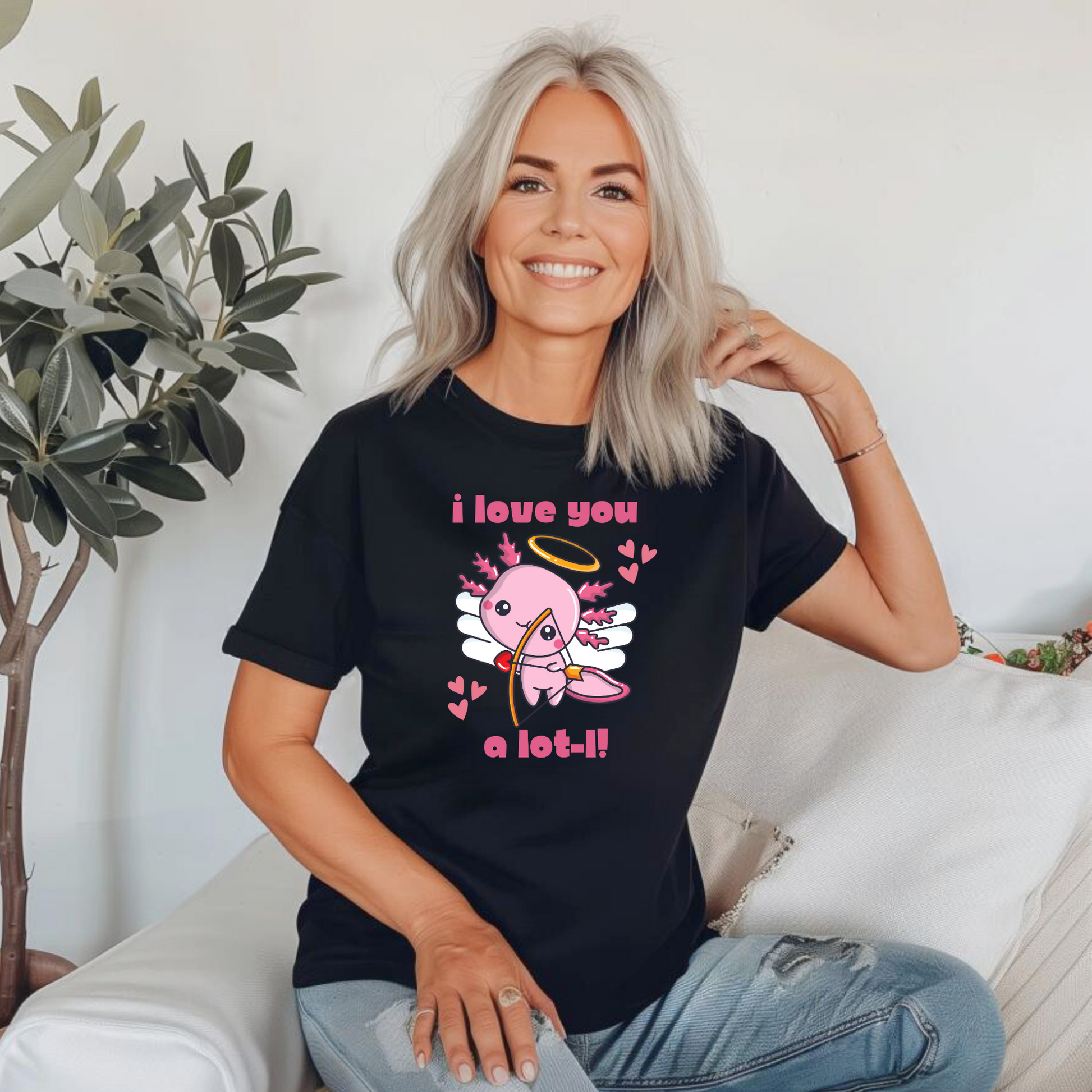 Women’s “I Love You A Lot-L” axolotl shirt with a pink cupid axolotl and heart accents, printed on Bella Canvas 3001 in sizes XS–XL. This Valentine’s Day graphic tee is a sweet, quirky option for teachers, girlfriends, wives, and animal lovers who enjoy fun fashion. Perfect for classroom celebrations, Valentine parties, or casual date night looks. Makes a thoughtful gift for axolotl fans and those who love unique, pun-inspired shirts.