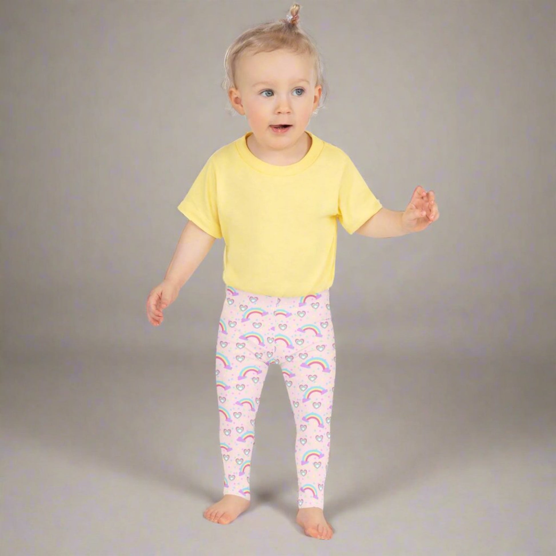 Pink Fairy Tale Girl Leggings. These pants feature a light pink background with a pattern of stars, hearts and rainbows, by jaecrece