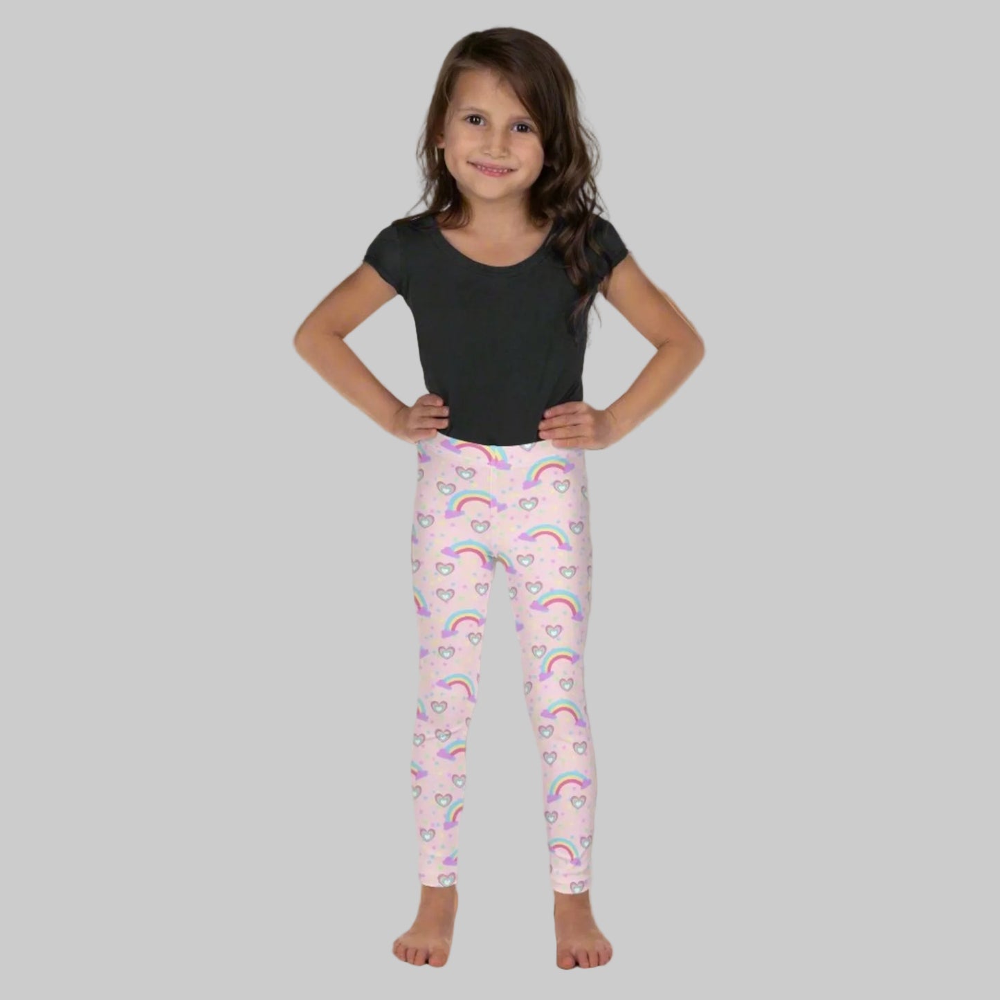 Pink Fairy Tale Toddler Girl Leggings. These pants feature a light pink background with a pattern of stars, hearts and rainbows, by jaecrece
