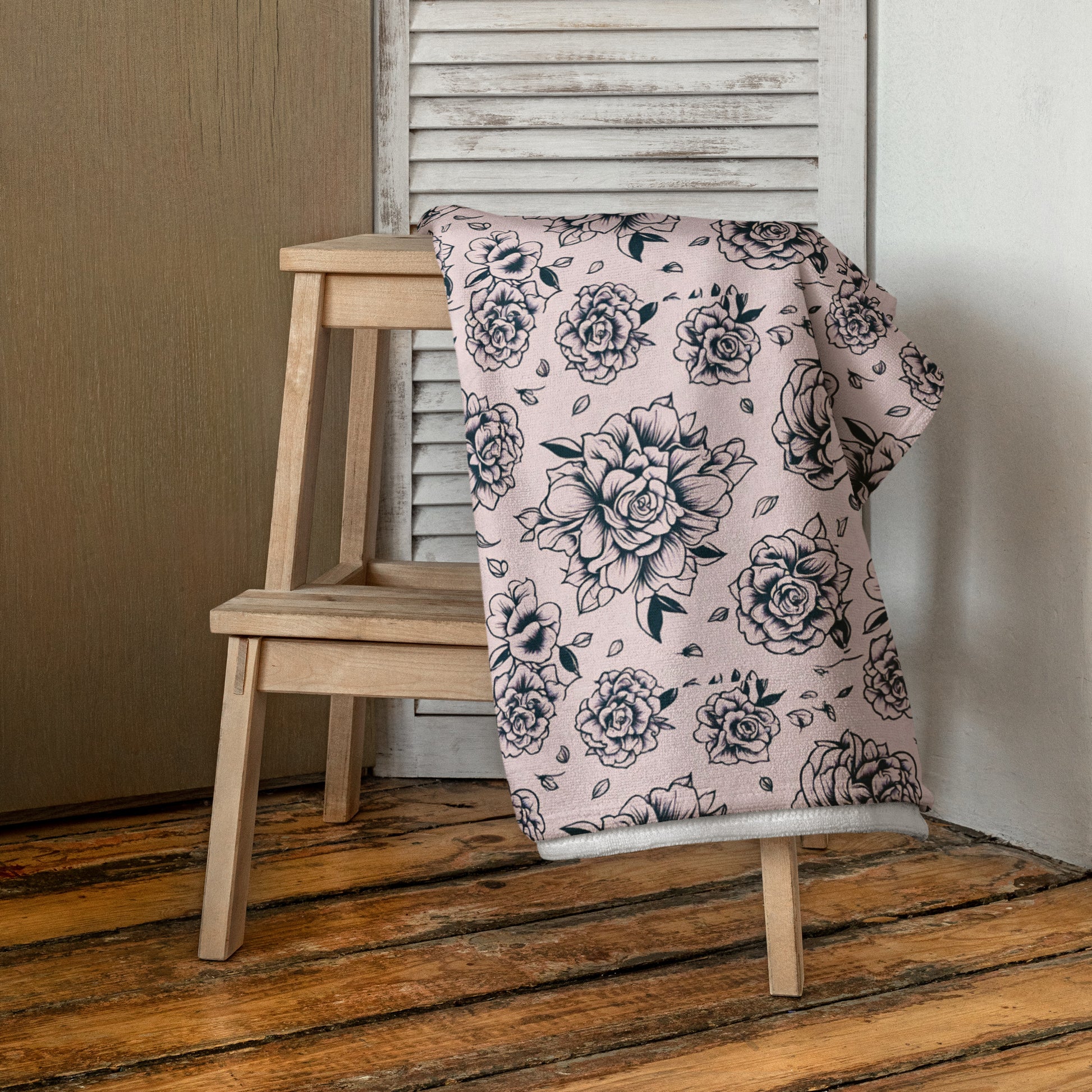 Pink Tattoo Rose Beach Towel displayed at the poolside, showcasing oversized 30×60″ design with bold black and pink tattoo rose print, soft cotton blend with absorbent terry backing, perfect for lounging, sunbathing, lake trips, vacations, and summer pool parties, lightweight and durable, coordinating with matching swimwear, trendy and statement summer accessory for women and girls.