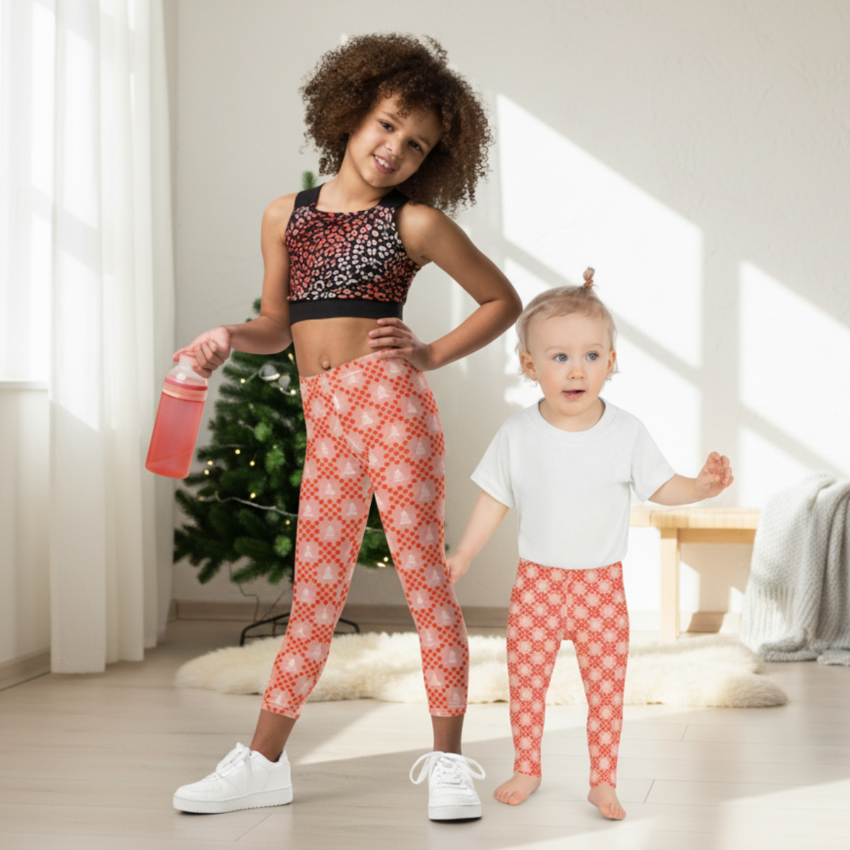 Pink Christmas leggings for girls featuring cream Christmas trees and playful red geometric shapes against a soft pink background. The colorful pattern gives these full length leggings a cheerful holiday look without using the traditional red and green Christmas palette. The design works well for Christmas morning, holiday parties, family gatherings, school celebrations, Christmas photos, and everyday winter outfits.