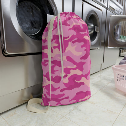 Pink camouflage laundry bag in front of a washing machine in a laundry room.