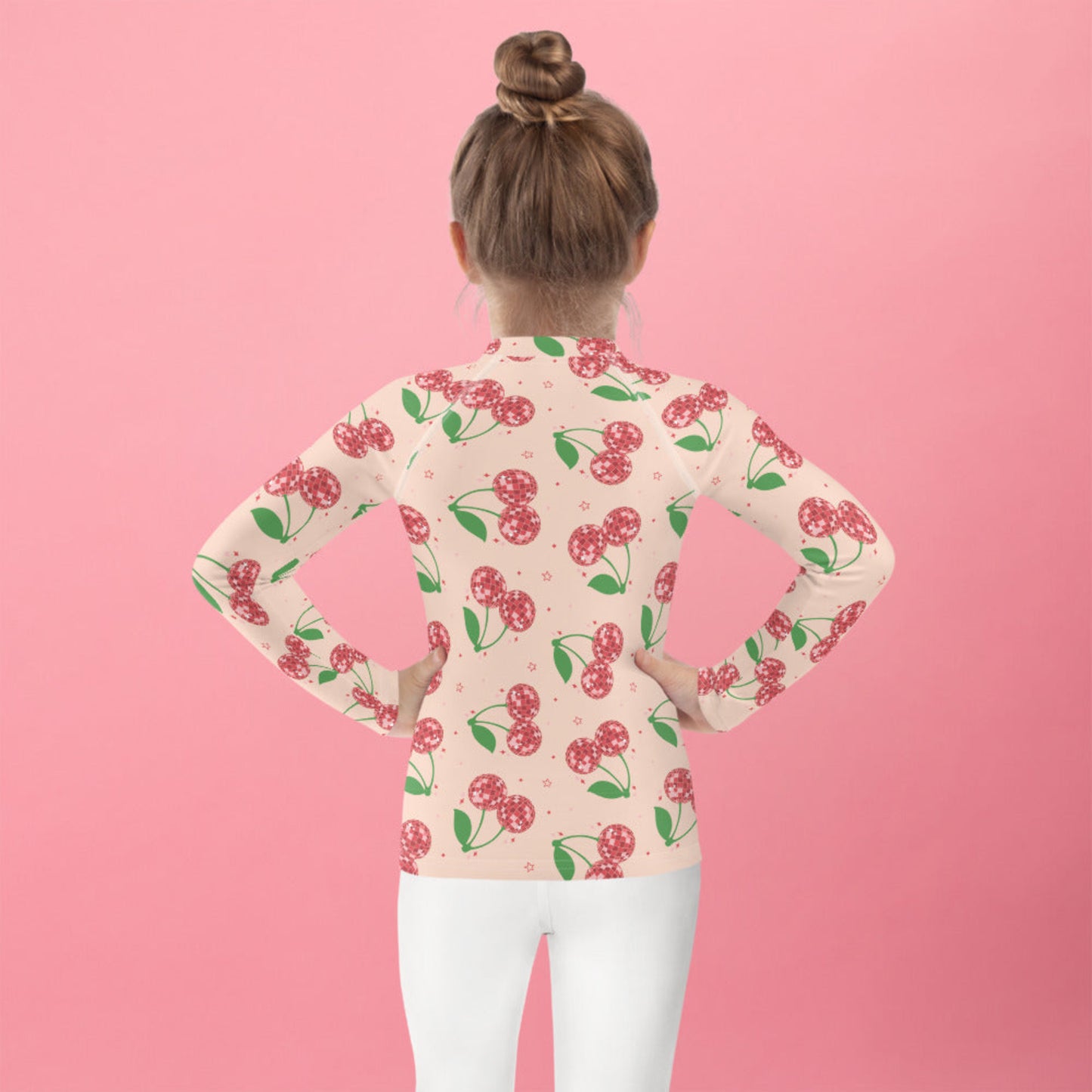 Pink cherry print girls rash guard with long sleeves and a fitted design, available in sizes 2T to 7. Features a playful disco cherry pattern on a soft pink base. Designed with UPF 50 protection to keep kids safe during outdoor play. Ideal for swimming, beach days, pool time, and summer vacations. Soft stretch fabric allows easy movement, and matching family swim options make it perfect for mommy and me outfits and coordinated vacation looks.