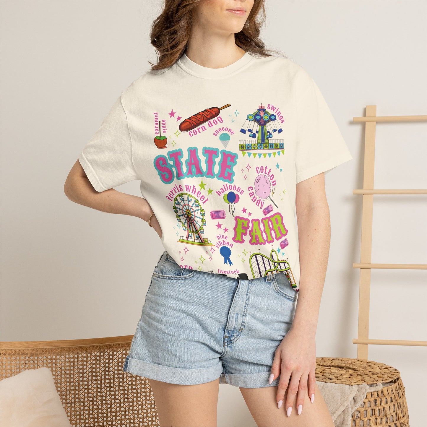 Retro Americana state fair artwork arranged as a playful collage on a graphic T shirt, with a Ferris wheel, roller coaster, carnival swing ride, cotton candy, corn dogs, funnel cake, balloons, livestock, blue ribbon and fair tickets paired with bright vintage style lettering and county fair details. Perfect for a nostalgic summer fair outfit.