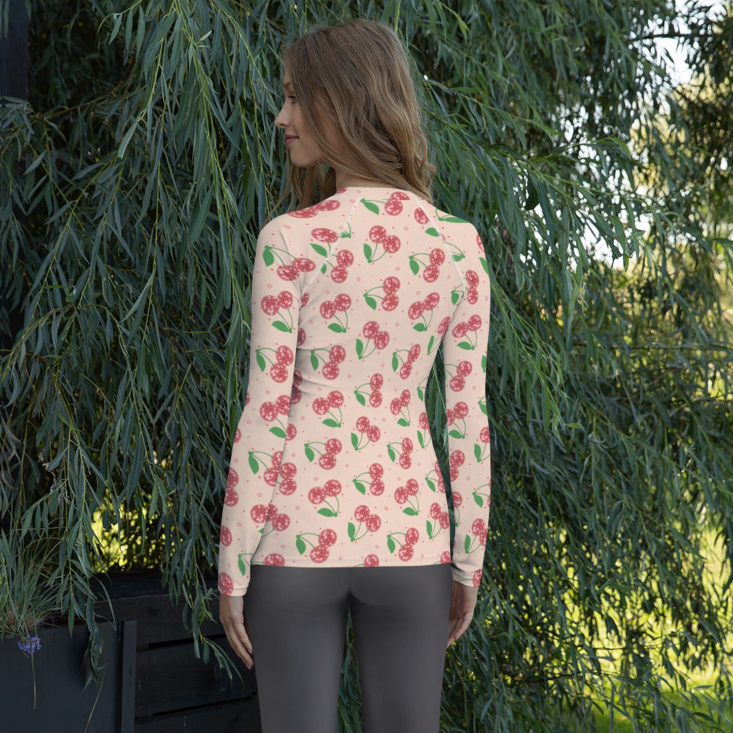 Colorful cherry print women’s swim shirt with a fun disco inspired pattern, fitted long sleeve design, and soft stretch fabric made for comfortable beachwear, water sports, vacations, and summer activities.