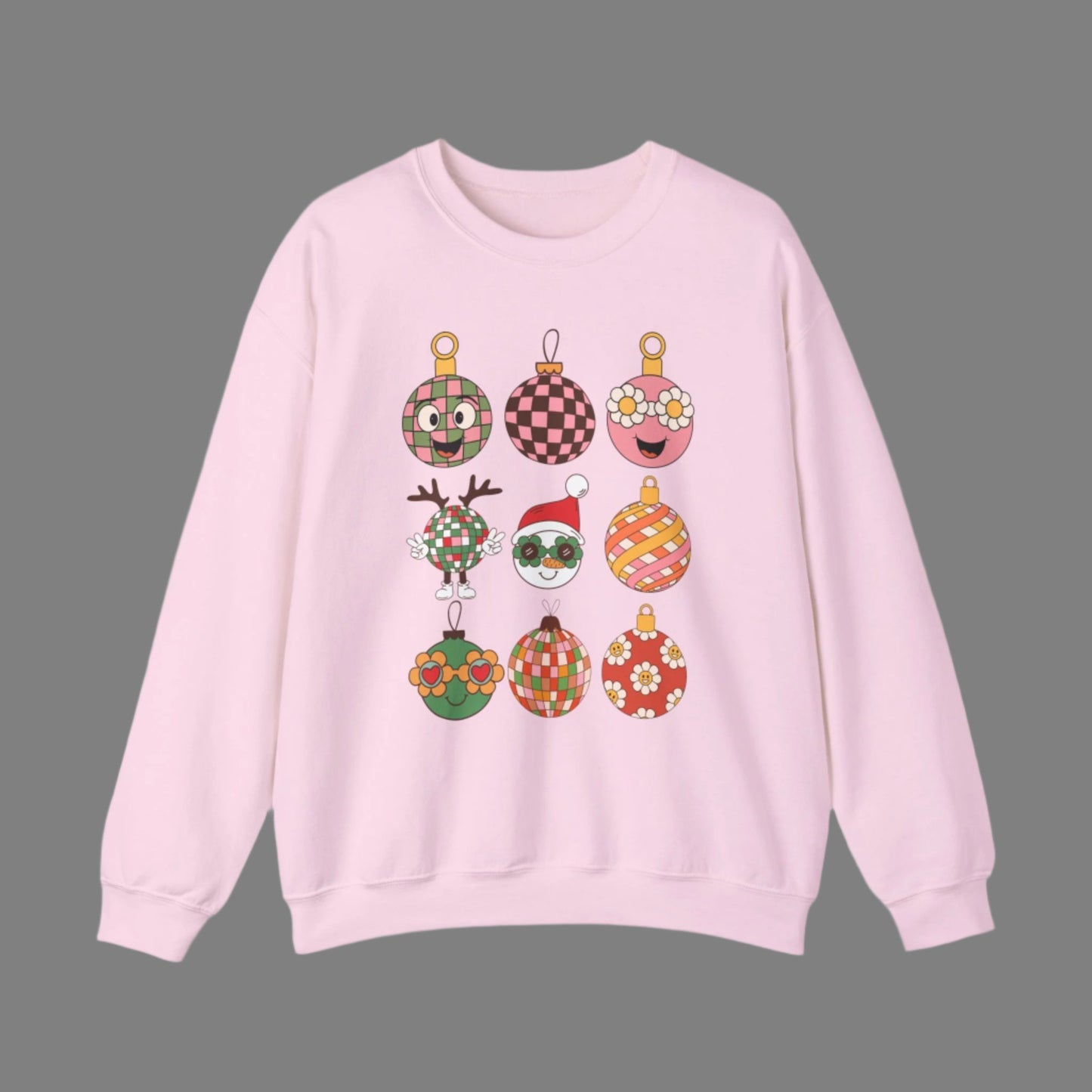 Retro Christmas Ornament Sweatshirt printed with nine quirky cartoon ornaments, including florals, plaids, and Santa wearing sunglasses. This unisex holiday pullover comes in sand, black, or light pink and is available in sizes S–5XL. Cozy medium-heavy fabric makes it warm for winter, while the retro design makes it a fun Christmas gift or holiday party outfit. Perfect for anyone who loves groovy vintage style and playful holiday fashion.