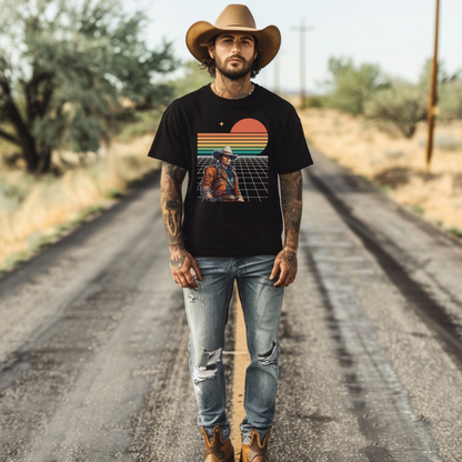 Man wearing a black t-shirt with an epic space cowboy retro futuristic graphic design, standing on a dirt road.