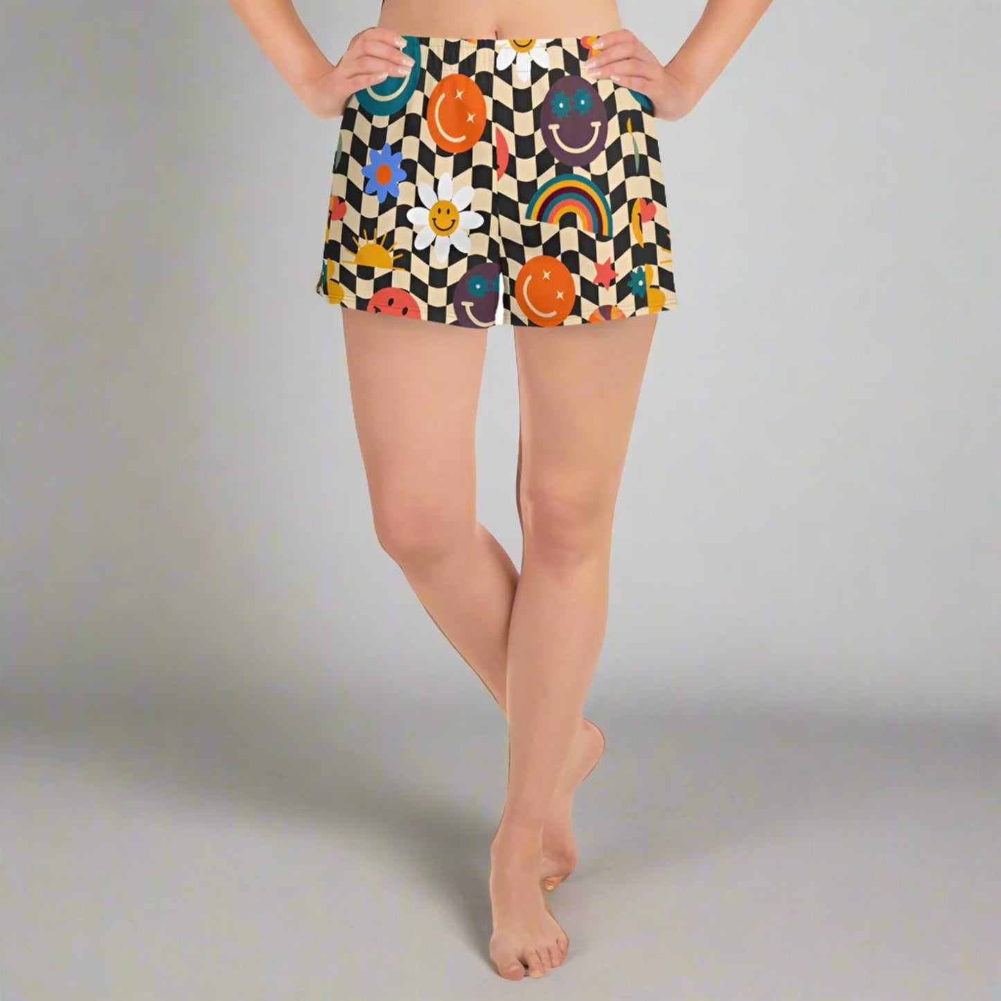 Smiley Face Checkerboard Ladies Athletic Shorts. These cute shorts feature a black and khaki checkerboard background, with smiley face, rainbow and daisy graphics. by jaecrece.com