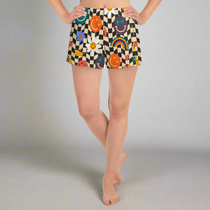 Smiley Face Checkerboard Ladies Athletic Shorts. These cute shorts feature a black and khaki checkerboard background, with smiley face, rainbow and daisy graphics. by jaecrece.com