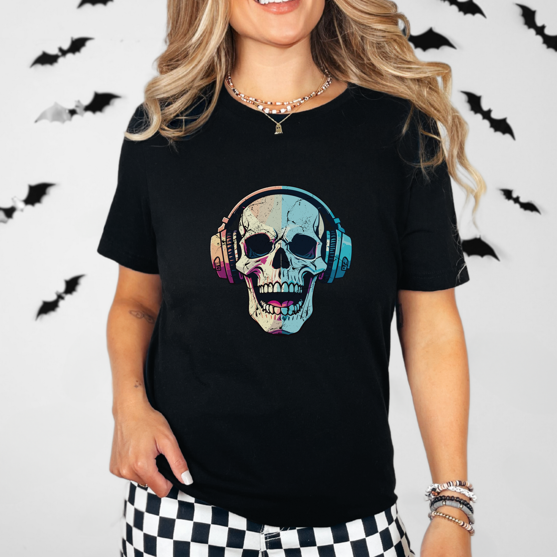 Woman wearing a black unisex “Spooky Sounds” graphic t-shirt featuring a colorful laughing skull with headphones. The design has an edgy gothic and music-inspired aesthetic, perfect for Halloween outfits, concert looks, or everyday alternative streetwear. Made from soft breathable cotton with a relaxed fit, this skull graphic tee is ideal for festivals, spooky season styling, or casual wear. black skull t-shirt, Halloween graphic tee, gothic music shirt, skull headphones shirt, alternative streetwear top.