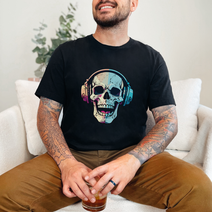man sitting on a couch wearing a black unisex graphic t-shirt featuring a colorful laughing skull wearing headphones. The bold “Spooky Sounds” design brings an edgy, gothic, music-inspired vibe that feels perfect for Halloween season or everyday alternative streetwear. Soft cotton fabric and relaxed fit make it ideal for concerts, festivals, or lounging at home. Black skull graphic tee, Halloween music shirt, gothic band style top, spooky aesthetic clothing, skull headphones t-shirt.