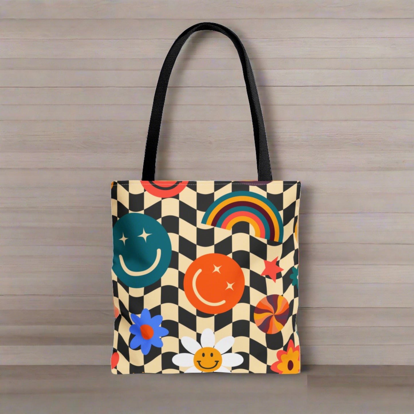 Smiley Face Checkered Canvas Tote Bag. This cute reusable carryall is eco friendly, and features a black and khaki checkerboard background, with smiley face, rainbow and daisy graphics. by jaecrece.com