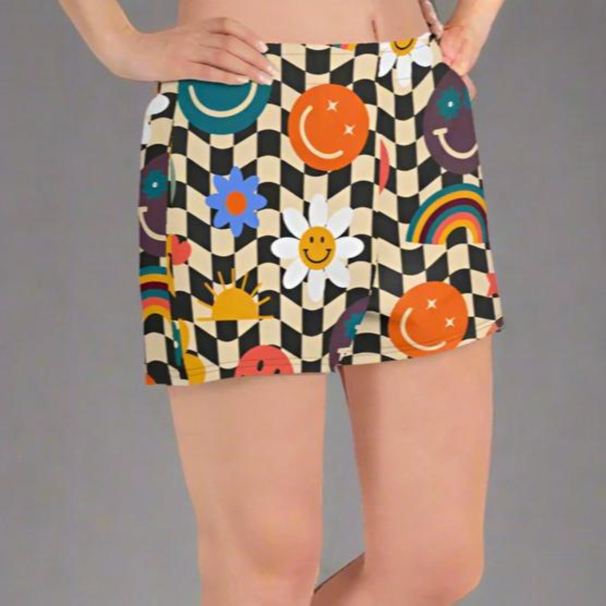 Smiley Face Checkerboard Ladies Athletic Shorts. These cute shorts feature a black and khaki checkerboard background, with smiley face, rainbow and daisy graphics. by jaecrece.com