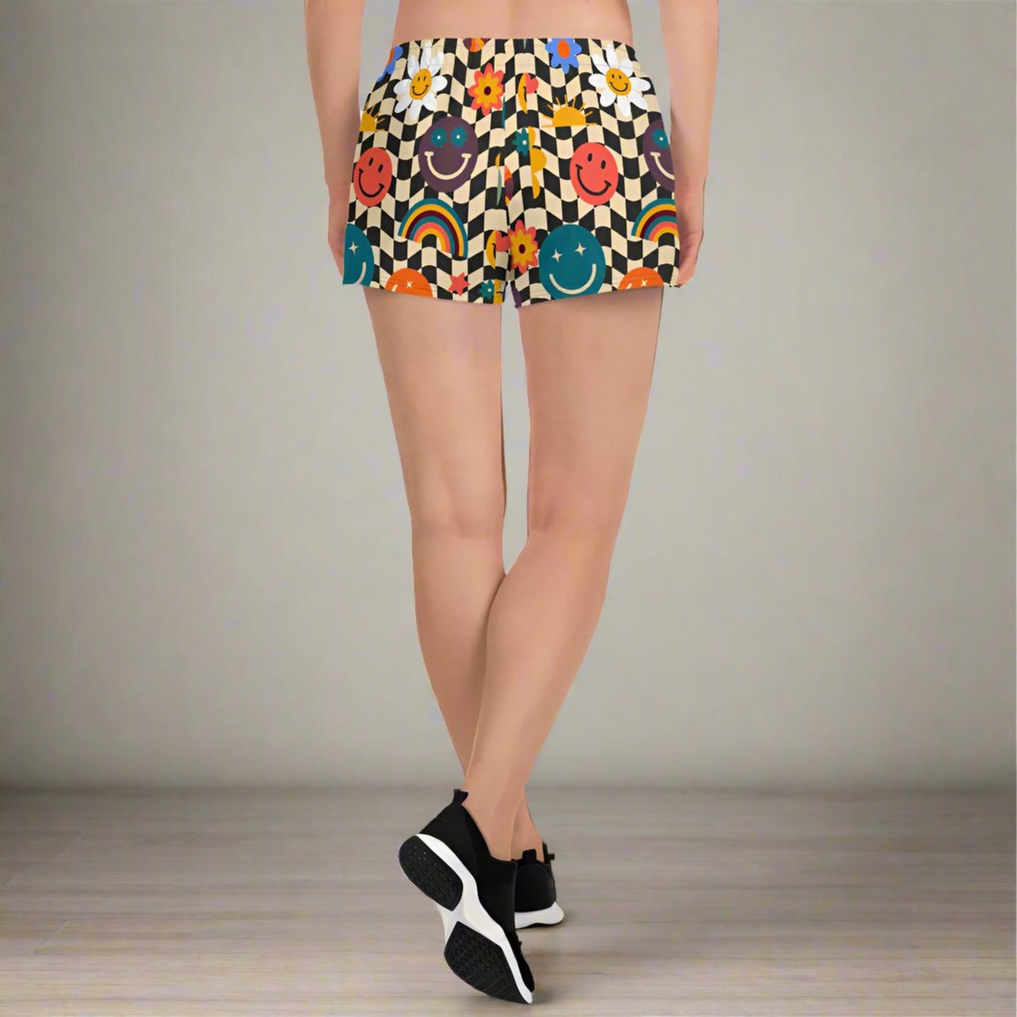 Smiley face checkerboard athletic shorts styled as part of a coordinated activewear set, featuring a retro beige and black wavy checker design with playful smiley accents. With mesh pockets, elastic waistband, fast drying breathable fabric, and a 2.5 inch inseam, these workout shorts are designed for sports, fitness, casual wear, and family matching outfits in sizes XS through 3XL.