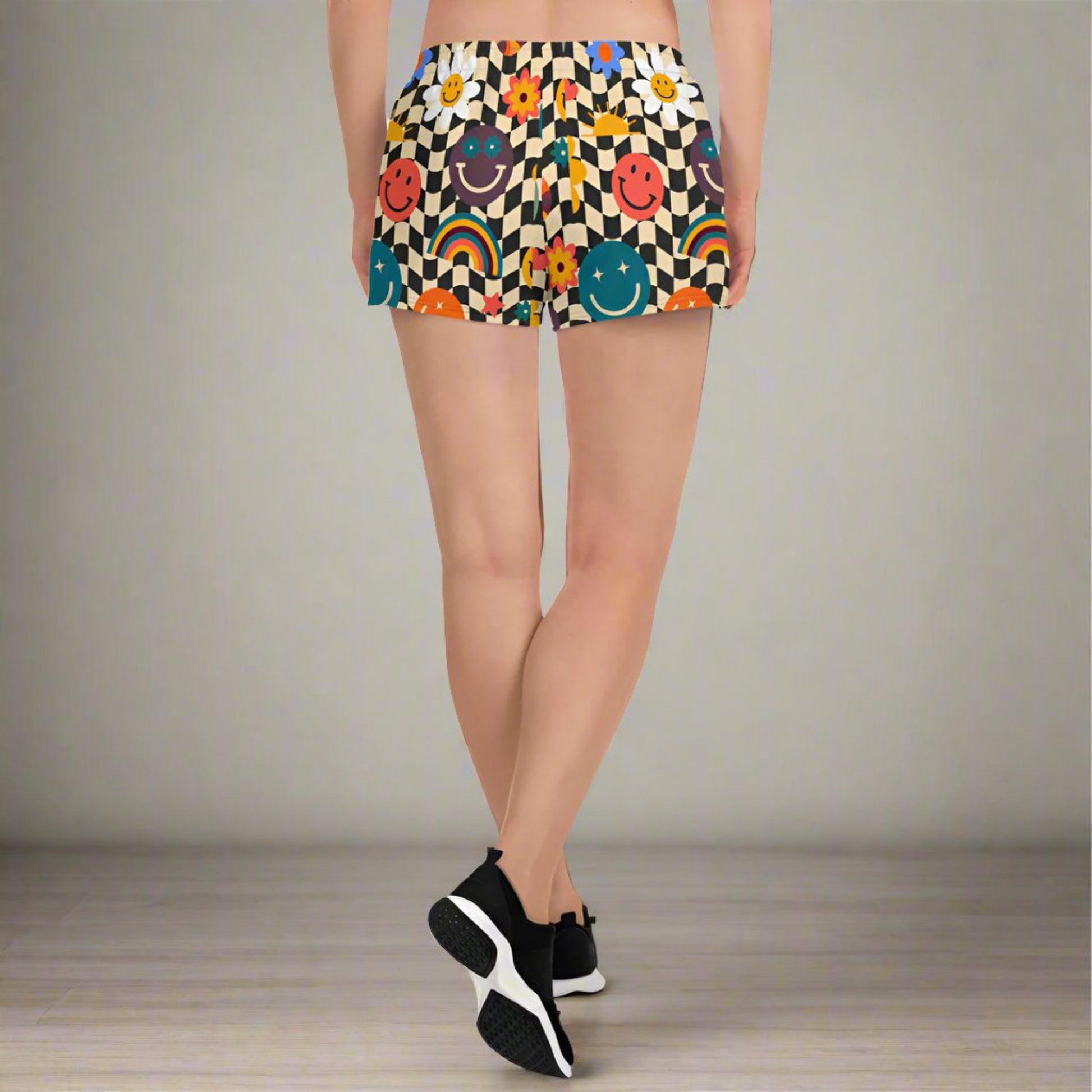 Smiley face checkerboard athletic shorts styled as part of a coordinated activewear set, featuring a retro beige and black wavy checker design with playful smiley accents. With mesh pockets, elastic waistband, fast drying breathable fabric, and a 2.5 inch inseam, these workout shorts are designed for sports, fitness, casual wear, and family matching outfits in sizes XS through 3XL.