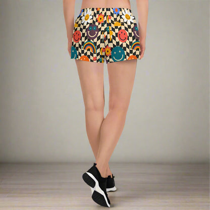 Smiley face checkerboard athletic shorts styled as part of a coordinated activewear set, featuring a retro beige and black wavy checker design with playful smiley accents. With mesh pockets, elastic waistband, fast drying breathable fabric, and a 2.5 inch inseam, these workout shorts are designed for sports, fitness, casual wear, and family matching outfits in sizes XS through 3XL.