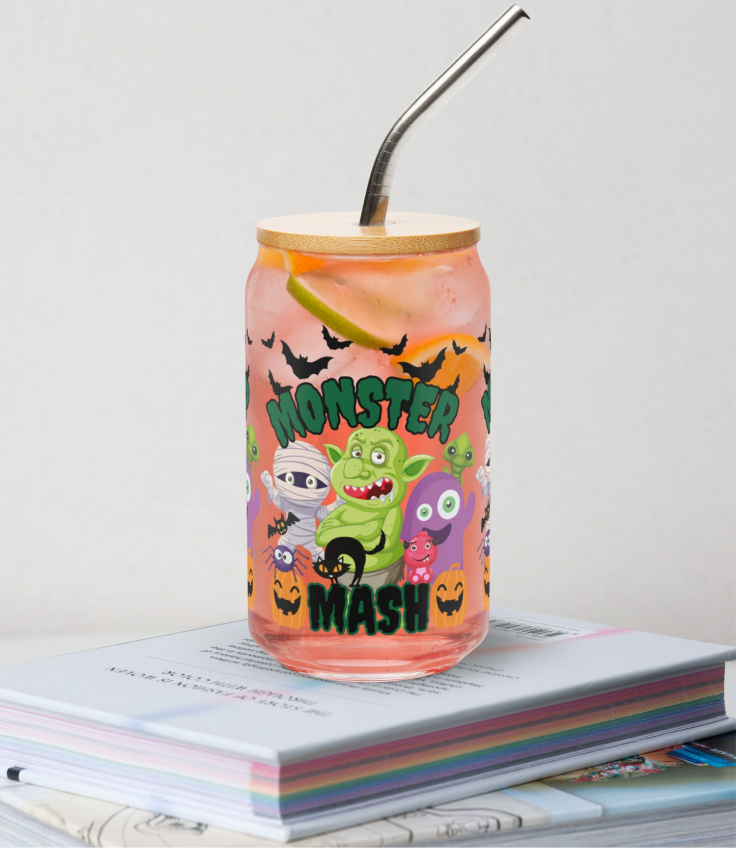 Spooky cute Monster Mash 16 oz glass can with bamboo lid and reusable straw, perfect for iced coffee, sodas, cocktails, or mocktails. Playful design features monsters, pumpkins, and bats that make it great for Halloween gatherings or cozy nights at home. Reusable eco-friendly drinkware option for fall, this tumbler also makes a fun seasonal gift. Trendy Halloween glass cup for spooky season entertaining.