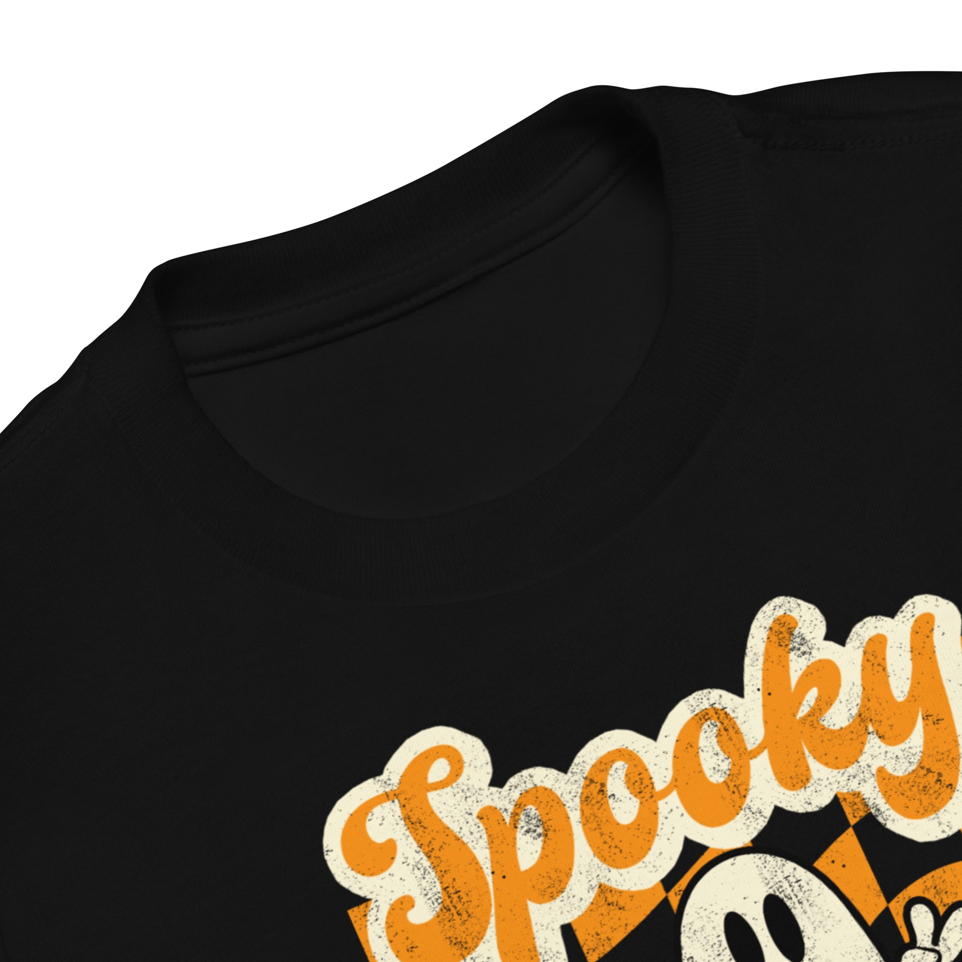 Cute Halloween toddler outfit shirt featuring Spooky Mini ghost graphic with peace sign on orange checkered retro aesthetic background printed on Bella Canvas 3001T cotton tee. Perfect for trick or treating, school Halloween parties, pumpkin patch visits, fall festivals, and cozy seasonal wear. Soft and comfortable fabric for all day toddler movement, plus matching Mama and Mini tees for adorable coordinated family Halloween outfits and photos.