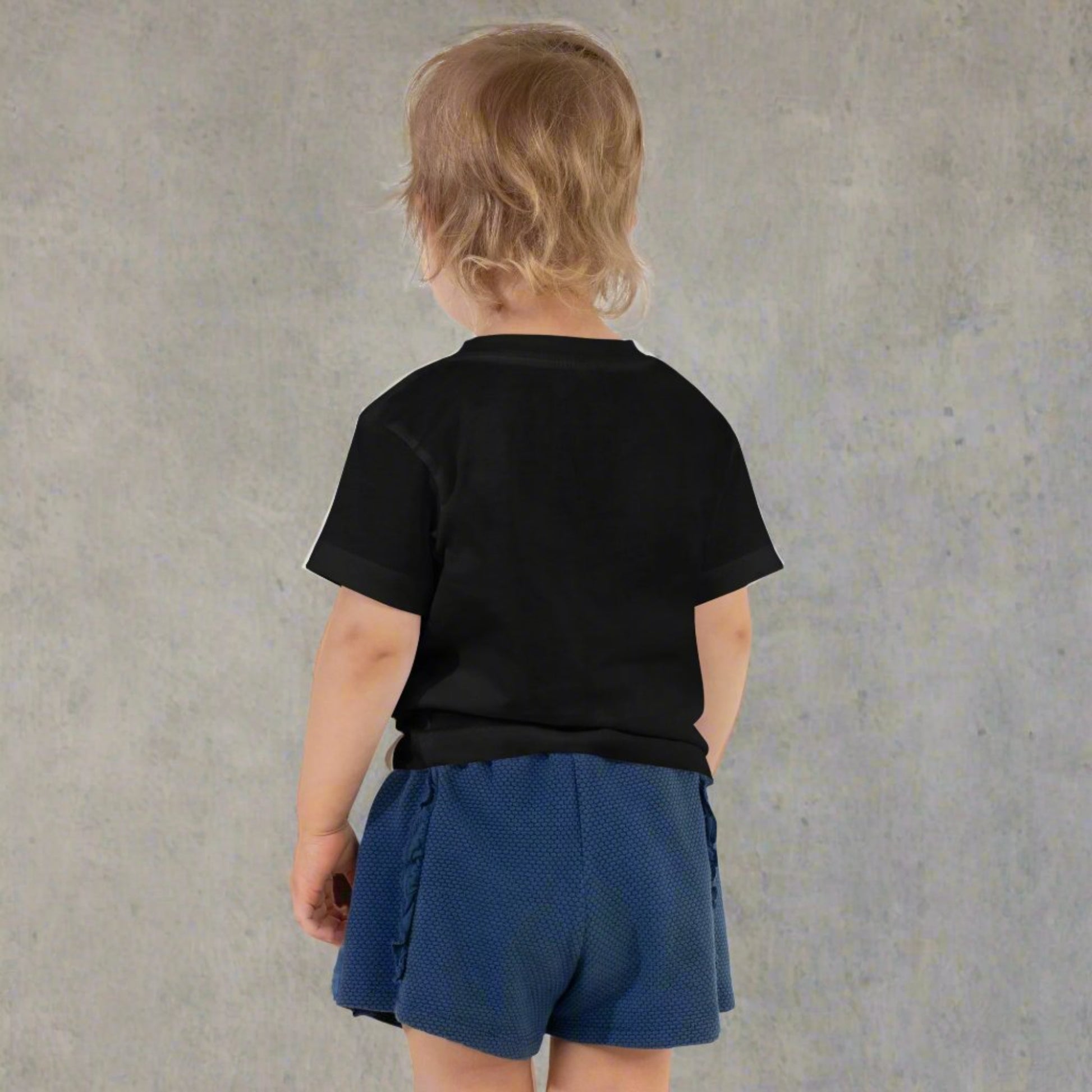 Back side of the Spooky Mini toddler tee featuring adorable ghost with peace sign hand gesture over orange checkered Halloween background printed on Bella Canvas 3001T lightweight cotton shirt. Perfect for fall wardrobe, Halloween parties, pumpkin patch adventures, trick or treating, and school events. Soft breathable fabric ensures comfort all day, while matching Spooky Mama shirt creates coordinated family matching Halloween outfits for moms and minis.