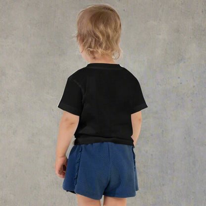 Back side of the Spooky Mini toddler tee featuring adorable ghost with peace sign hand gesture over orange checkered Halloween background printed on Bella Canvas 3001T lightweight cotton shirt. Perfect for fall wardrobe, Halloween parties, pumpkin patch adventures, trick or treating, and school events. Soft breathable fabric ensures comfort all day, while matching Spooky Mama shirt creates coordinated family matching Halloween outfits for moms and minis.