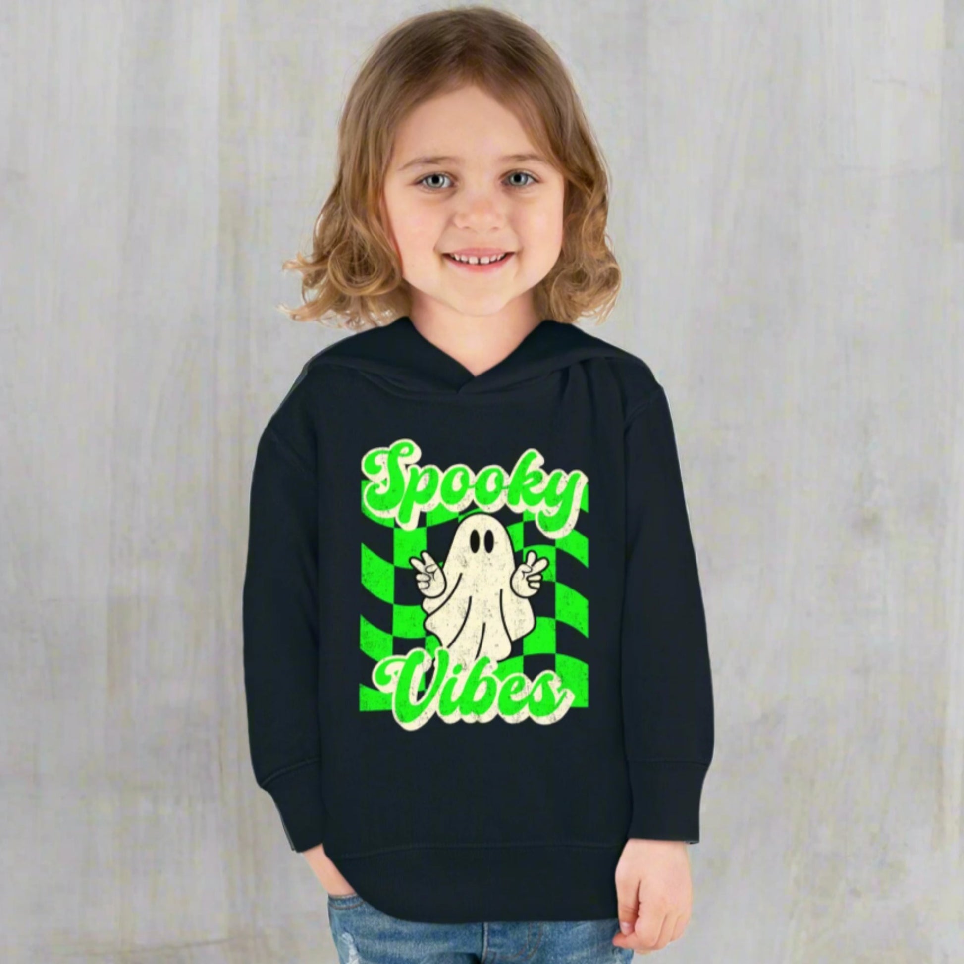 Spooky Vibes Halloween Toddler Hoodie. Featuring a green checkerboard design with a cute ghost giving peace signs, with the text spooky vibes. Mommy and Me/ Family Matching options, by jaecrece