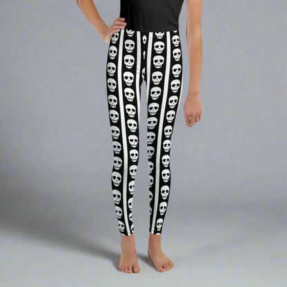 Spooky skull print leggings for girls and tweens featuring black and white striped design with vertical skull pattern detailing. Full length youth leggings in sizes 8 to 20 made with soft stretch fabric for comfort and flexibility. Perfect tween Halloween outfit, casual school wear, or fall themed fashion. Trendy gothic style leggings for kids who love bold patterns and alternative aesthetic clothing.