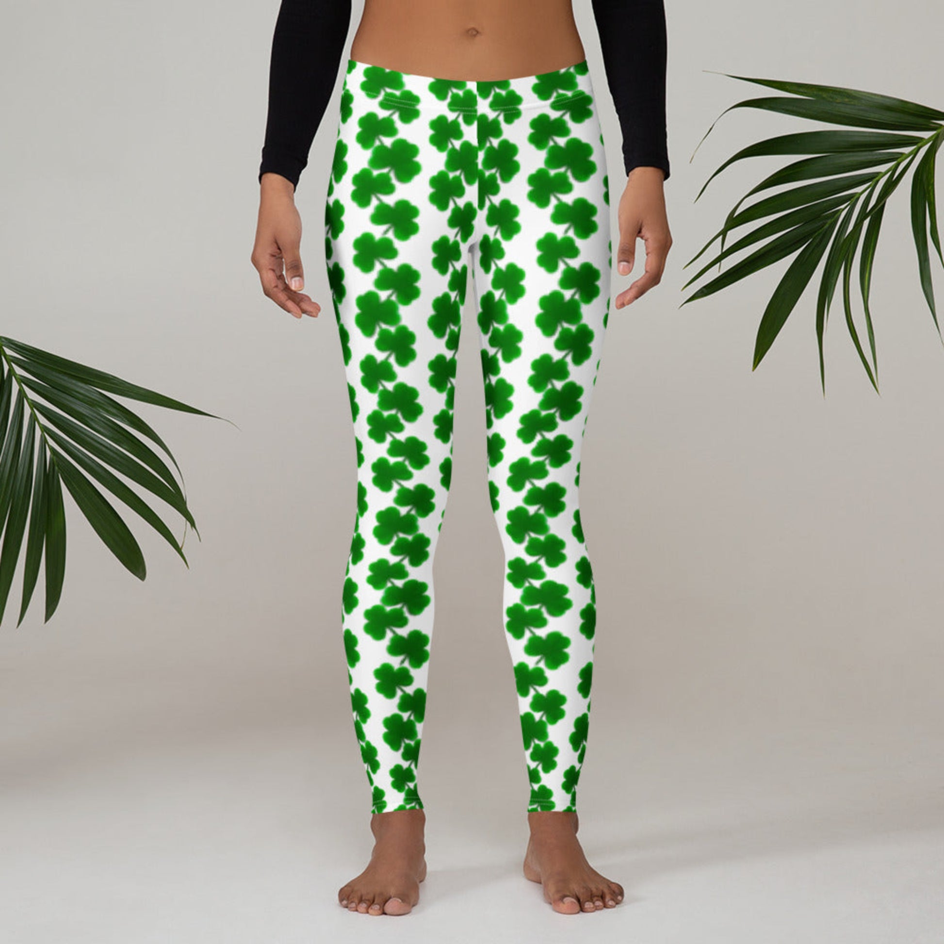 Image: St Patricks Day Leggings for toddler girls, tween, teens and women. The yoga pants are white with a green shamrock pattern. These women’s St. Patrick’s Day leggings feature an all-over shamrock design on a white background with a mid-rise waistband and full-length legs. Designed for comfort and flexibility, they’re ideal for festive holiday looks, casual wear, or matching with kids for a coordinated family outfit. Available in sizes XS to XL, these fun leggings are perfect for celebrating in style.