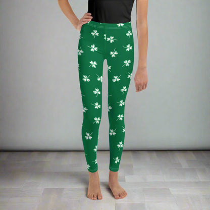 Image: Family Matching St Patricks Day Shamrock Leggings. Festive yoga pants with green background and white four leaf clovers. Available in sizes for toddler girls, teens, tweens, and women. Perfect for a St Pattys Day parade or fun run, by jaecrece