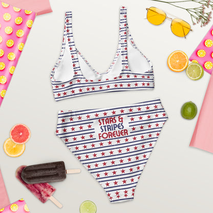 Back view of a woman modeling a patriotic bikini with red stars and blue stripes printed across both pieces. The high waisted bottoms provide a flattering silhouette while the scoop neck bikini top offers a classic and comfortable fit. Stars and Stripes Forever is printed across the back, creating a bold patriotic statement for summer wear.