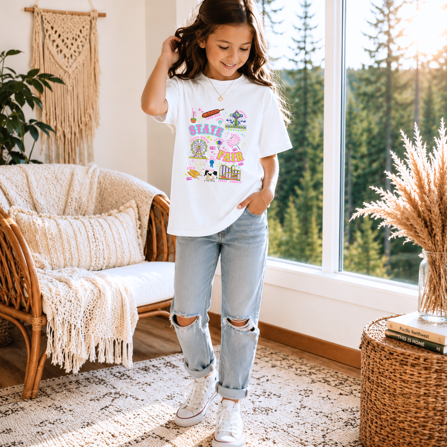 Youth county fair graphic tee featuring colorful retro Americana artwork with carnival rides, fair food and livestock show details. The design includes a Ferris wheel, roller coaster, cotton candy, funnel cake, corn dogs, balloons, blue ribbon, livestock and fair tickets for a playful state or county fair day outfit.