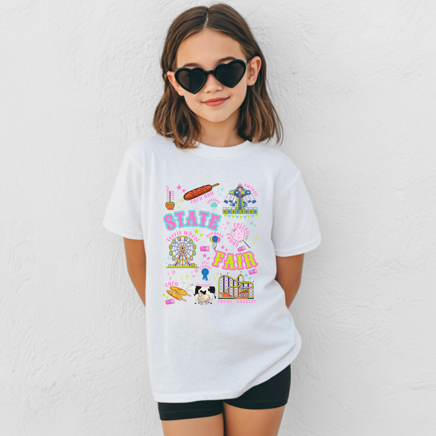 Kids State Fair and County Fair graphic T shirt featuring colorful retro artwork with a Ferris wheel, roller coaster, carnival ride, cotton candy, funnel cake, corn dogs, balloons, livestock, blue ribbon and fair tickets. The playful design has a nostalgic Americana style perfect for summer fairs and family outings.