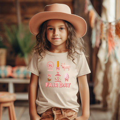 Image: A charming Fair Day shirt with bold red and white gingham letters spelling out Fair Day, surrounded by fun carnival themed graphics including cotton candy, a Ferris wheel, a caramel apple, a pig, a corn dog, and classic carnival rides. Designed in a soft girl coquette aesthetic, this top is perfect for state fairs, county fairs, livestock shows, or fun themed birthday parties. Available in toddler, girls, and women's sizes for matching outfits, by jaecrece.
