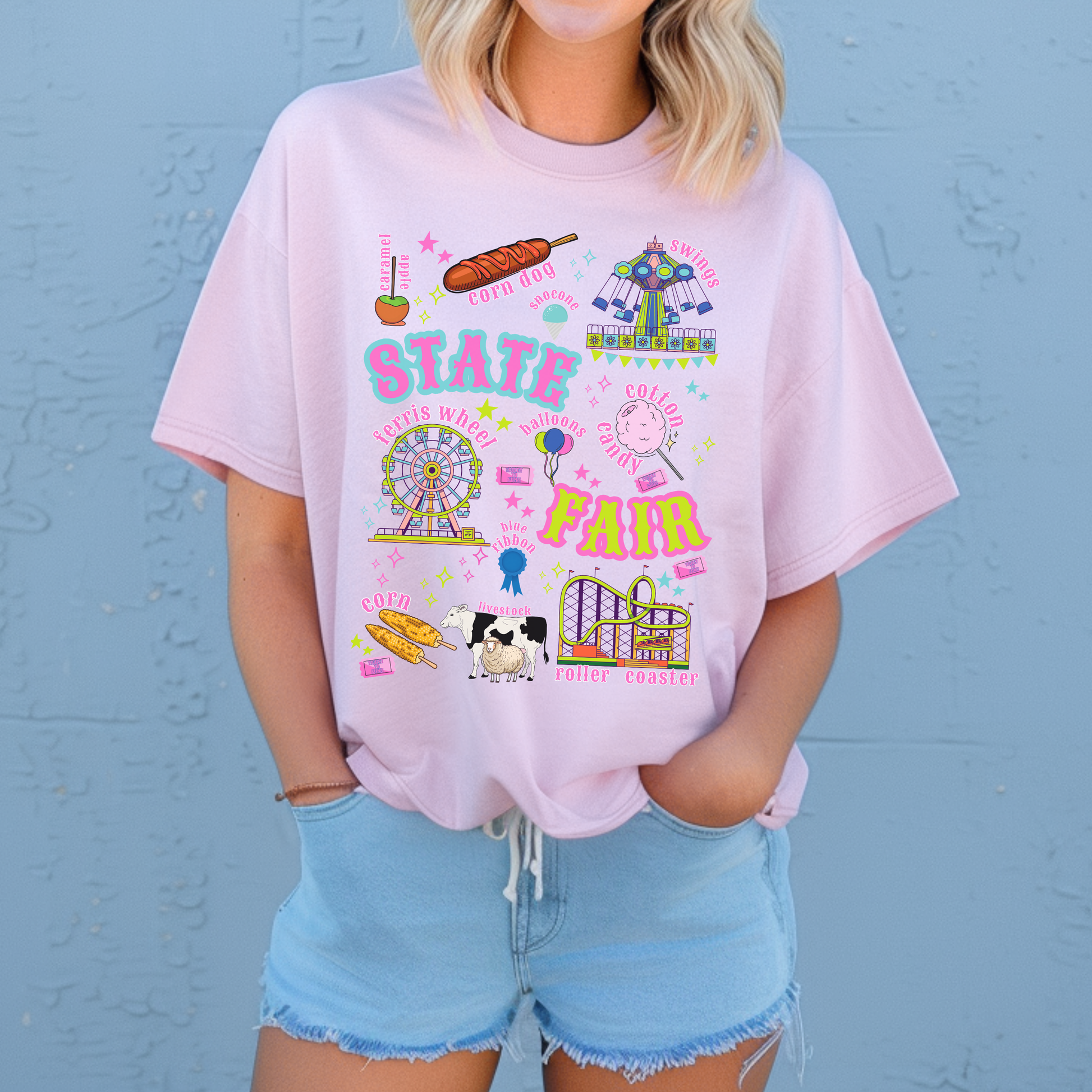 Retro carnival artwork for a state fair T shirt includes a Ferris wheel, roller coaster, swing ride, cotton candy, balloons, funnel cake, corn dogs, livestock, prize ribbon and fair tickets. Bright pink, aqua, lime, orange and purple details give the graphic a playful vintage Americana feel with a retro summer feel.