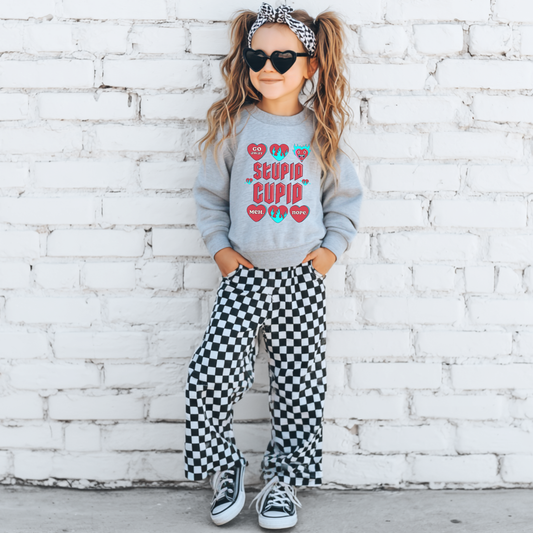 Stupid Cupid youth sweatshirt with bold 90s Y2K graphic, anti Valentine design, and colorful conversation hearts. Soft Gildan 18000B pullover in Dark Heather, Black, White, and Sport Gray, XS–XL. Cozy and playful, perfect for kids and tweens, school parties, casual wear, layered outfits, sarcasm lovers, holiday alternative, tween fashion, gift for kids, anti Valentine sweatshirt.