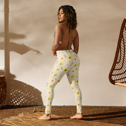 Full length sunflower leggings for women featuring yellow flowers, green foliage, and delicate botanical details against a soft cream background. The floral pattern has a hand painted appearance that gives the leggings a relaxed cottagecore and vintage botanical aesthetic. The ankle length design pairs easily with tees, sweaters, cardigans, denim jackets, sandals, or other casual wardrobe favorites.
