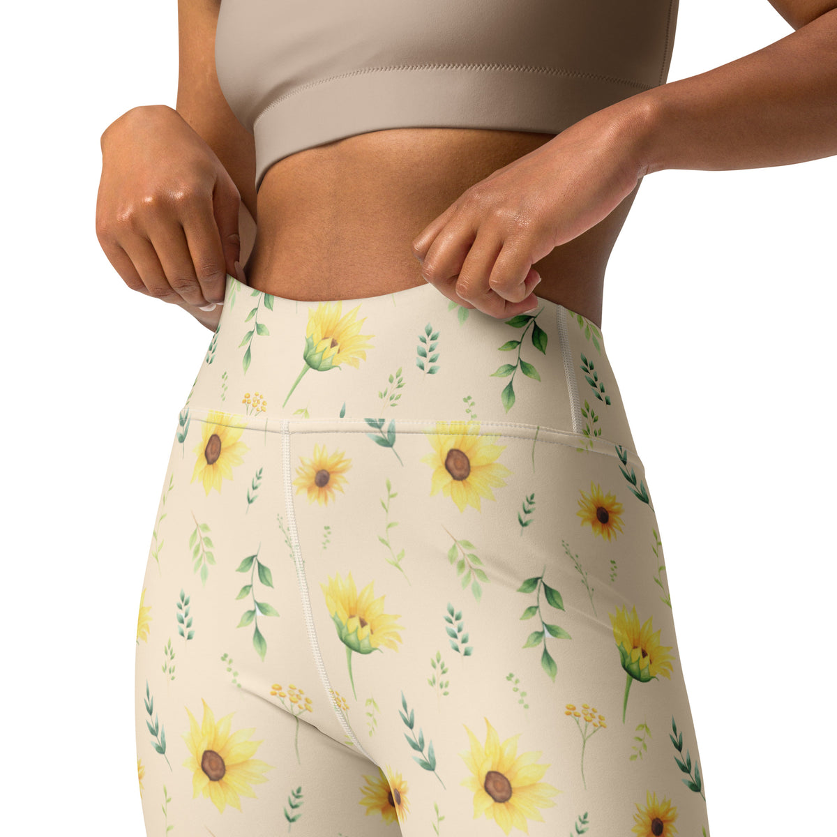 Front view of women's leggings featuring a delicate sunflower and botanical print on a soft cream background. Yellow sunflowers are scattered among slender green leaves and small leafy sprigs for a cheerful garden inspired look. The full length leggings have a high rise waistband and smooth stretchy fabric, making them easy to style for casual outfits, yoga, walking, travel, lounging, or warm weather days.