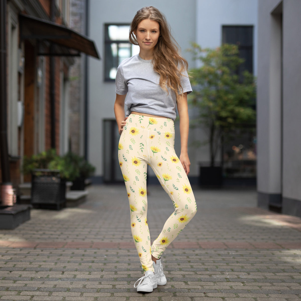 Wildflower women's leggings styled as an easy everyday outfit. The cream background and yellow floral print create a soft botanical look that pairs naturally with simple tops and casual accessories. The leggings feature a full length design and high rise waistband with flexible fabric for comfortable movement. They are a cheerful option for errands, travel, outdoor activities, casual gatherings, farmers markets, or relaxed weekends.