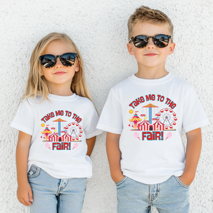 Two children, a girl and a boy, wearing white crew neck T-shirts with a graphic design 'Take Me to the Fair' and colorful fairground imagery, paired with blue denim jeans and sunglasses.