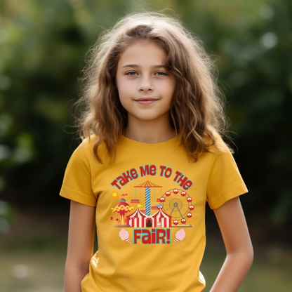 Young girl wearing mustard crew neck T-shirts with a graphic design 'Take Me to the Fair' and colorful fairground imagery