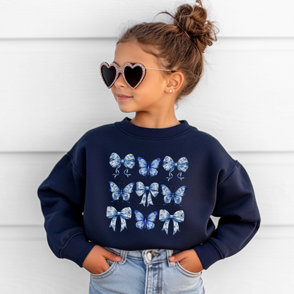 Navy and White Blue Toile Girls Sweatshirt featuring playful butterflies and bows in an elegant toile design. Sized XS–XL for girls and tweens, this cozy top aligns with soft girl, Texas coquette, and coastal cowgirl aesthetics. Ideal for layering in spring or fall, pairing with jeans, leggings, or skirts. Part of a matching family collection for sibling outfits or mom and daughter photos. A charming birthday gift or wardrobe staple that blends whimsical cottagecore charm with boutique style for girls.