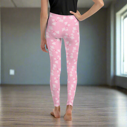 Image: Tween and teen girls will love these youth-sized leggings with pink gingham bows and a soft coquette vibe. Available in sizes 8 through 20, these leggings are great for casual days or dressing up with friends. With cozy fabric and a sweet aesthetic, they are an excellent birthday gift or addition to a stylish school wardrobe, by jaecrece.