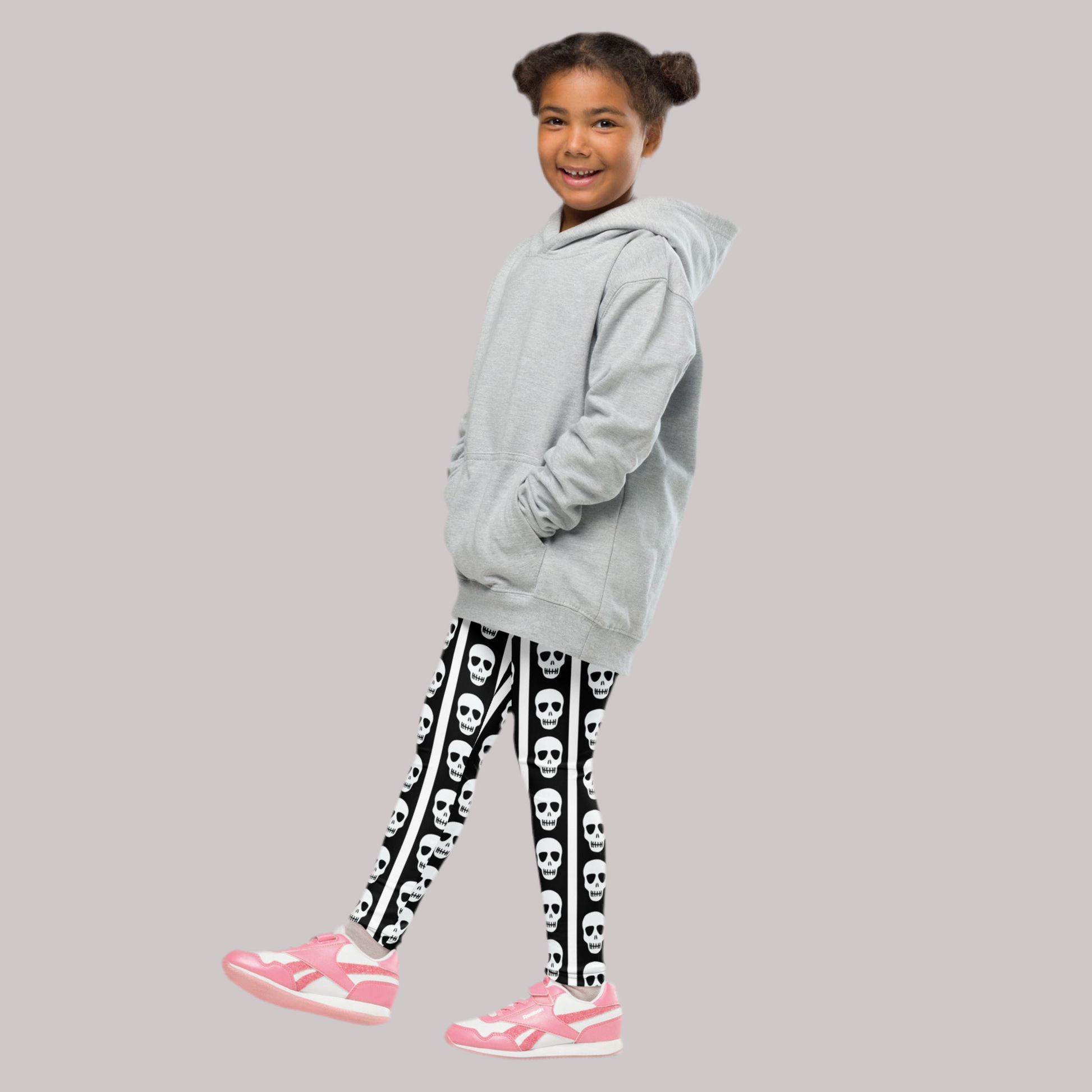 Image: These fun kids leggings feature bold black and white vertical stripes with a playful row of skulls running down each leg. Designed for toddlers and children who love spooky style or Halloween vibes, these leggings offer comfort and stretch for active play. Available in toddler and youth sizes, they are perfect for dress-up days, theme parties, or everyday outfits with a little edge, by jaecrece.