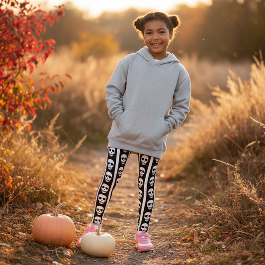 Image: These fun kids leggings feature bold black and white vertical stripes with a playful row of skulls running down each leg. Designed for toddlers and children who love spooky style or Halloween vibes, these leggings offer comfort and stretch for active play. Available in toddler and youth sizes, they are perfect for dress-up days, theme parties, or everyday outfits with a little edge, by jaecrece.