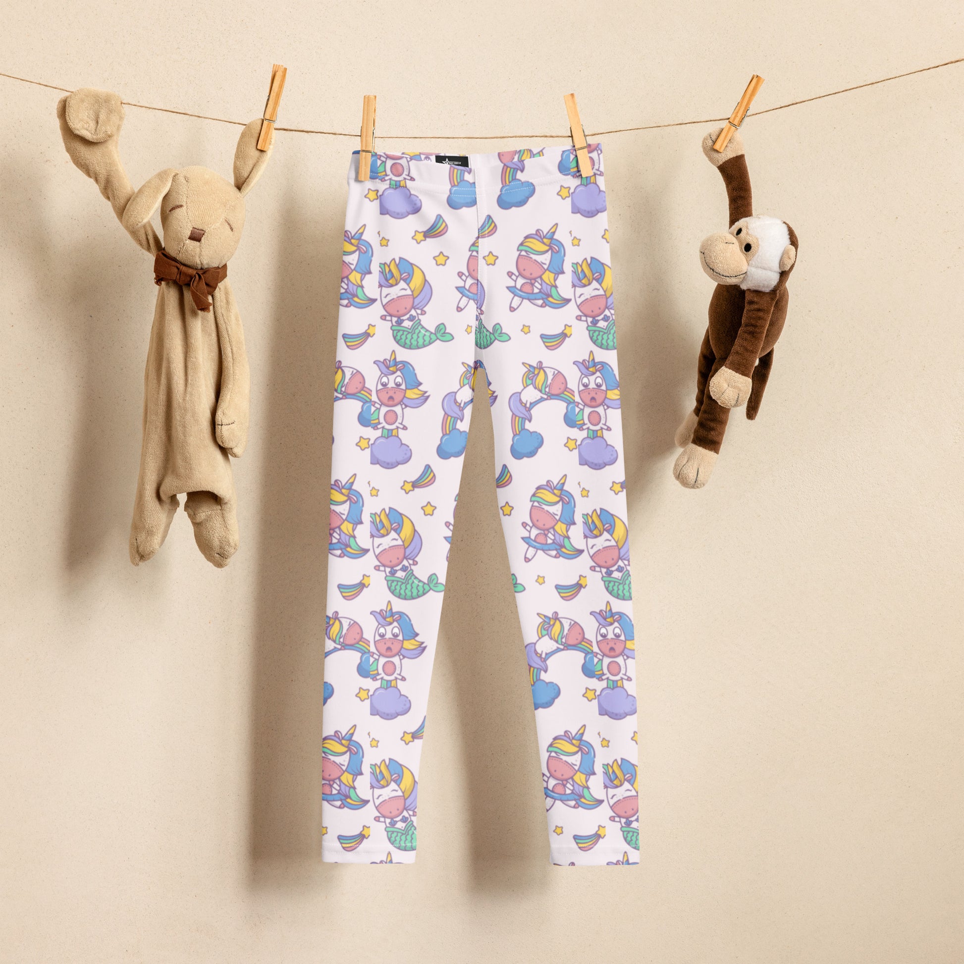 Kawaii inspired girls leggings featuring a magical mix of unicorns, mermaids, rainbows, and stars on a soft pastel pink background. Designed with a high rise waist and full length cut, these leggings are perfect for everyday outfits, school clothing, or playtime adventures. Soft stretchy material provides comfort and flexibility for active kids. A playful and imaginative fashion piece for girls who enjoy fantasy themed clothing.