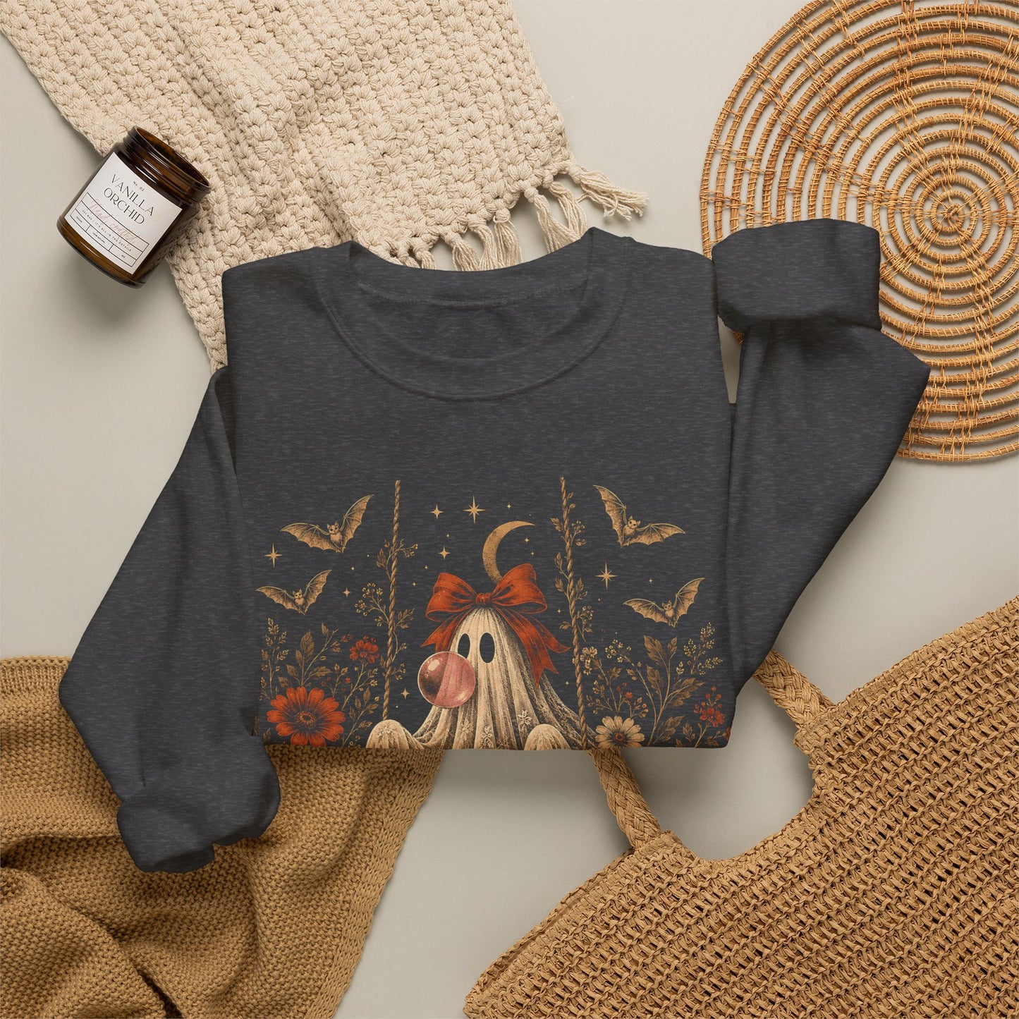 Women's vintage floral Halloween sweatshirt featuring a ghost sitting on a swing and blowing a bubble with bubble gum. Flowers, botanical foliage, bats, lace, stars and a crescent moon surround the ghost in an intricate whimsical design for fall.