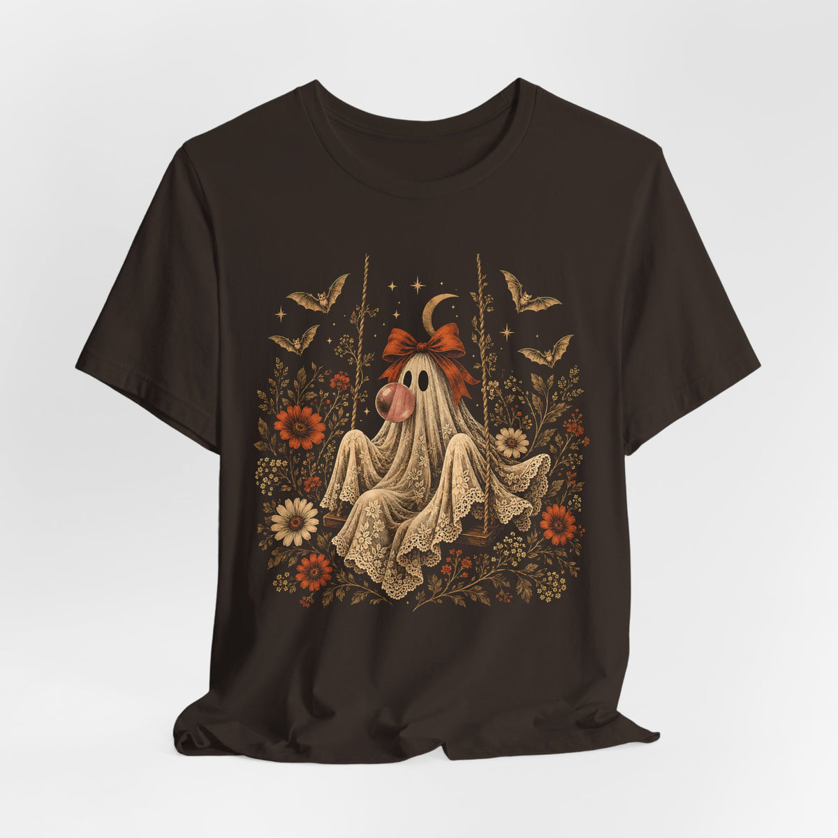 Women's vintage floral Halloween tee featuring a ghost sitting on a swing and blowing a bubble with bubble gum. Flowers, botanical foliage, bats, lace, stars and a crescent moon surround the ghost in an intricate whimsical design for fall.