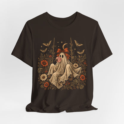Women's vintage floral Halloween tee featuring a ghost sitting on a swing and blowing a bubble with bubble gum. Flowers, botanical foliage, bats, lace, stars and a crescent moon surround the ghost in an intricate whimsical design for fall.