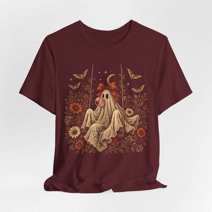 Vintage Halloween graphic tee featuring a ghost on a swing blowing bubble gum beneath a crescent moon. The detailed artwork includes flowers, leaves, bats, lace and stars, creating a whimsical spooky design for fall outfits and Halloween gatherings.