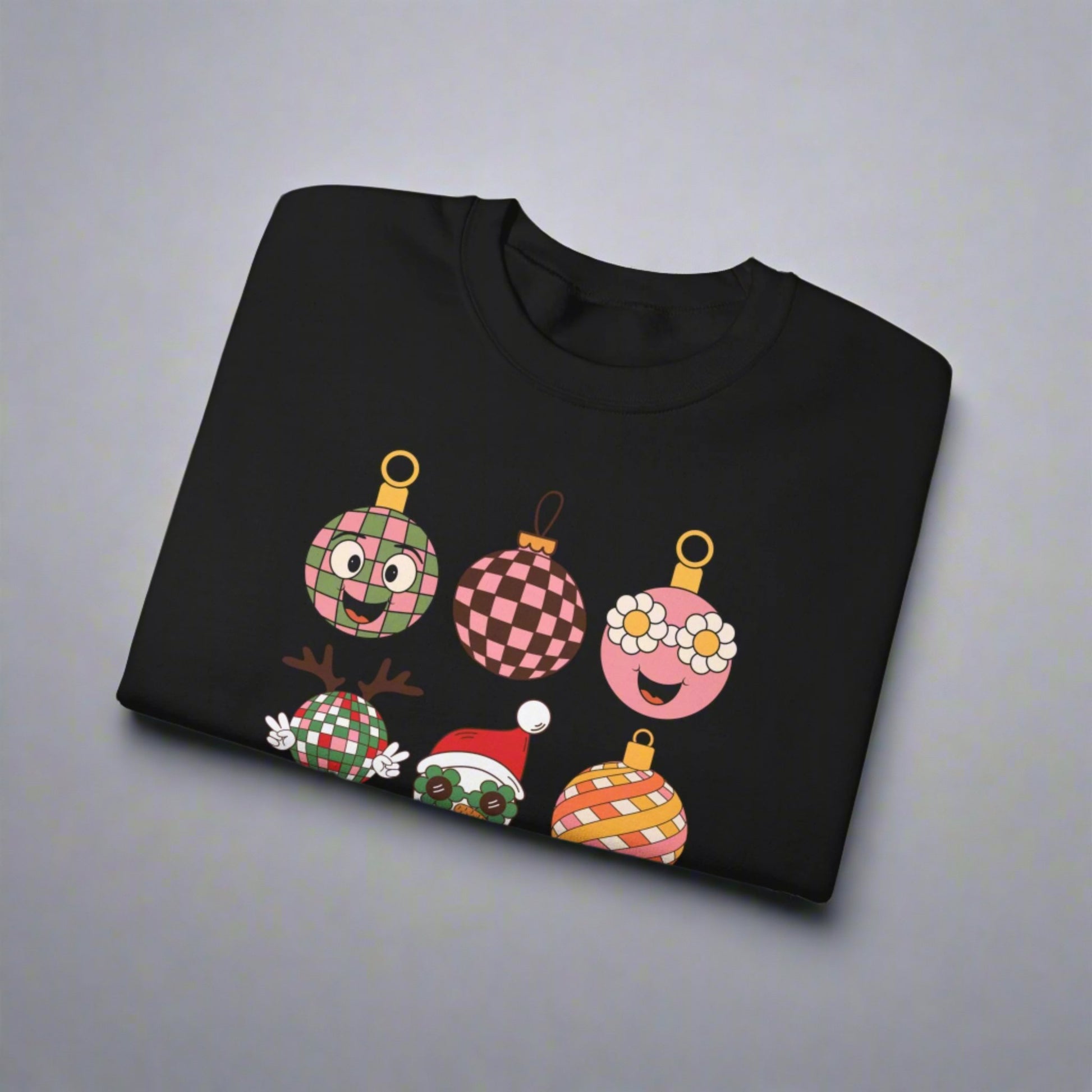 Retro Christmas Ornament Sweatshirt with nine whimsical ornament cartoon characters, each featuring a fun vintage-inspired design. From daisy florals to groovy checks and Santa in sunglasses, this playful Christmas crewneck is available in sand, black, or pink. Sizes S–5XL make it versatile for holiday gifting, matching family looks, or festive parties. Cozy, durable, and printed on Gildan 18000, it’s a must-have retro Christmas pullover.