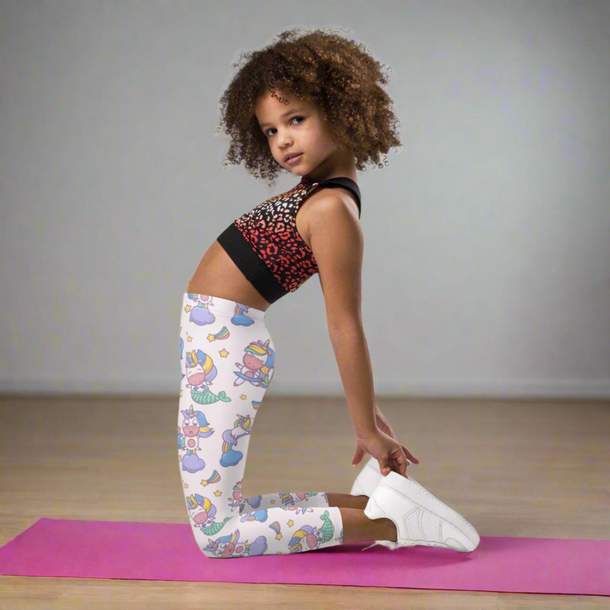 Girls full length leggings with a playful mermaid unicorn design on a soft pink base, featuring whimsical details like stars, clouds, and rainbows. Designed for toddlers and young girls, these high waist leggings offer a comfortable fit that stays in place throughout the day. The stretchy fabric is soft to the touch and moves easily with active play. Perfect for school days, casual outings, or cozy time at home for kids who enjoy fun fantasy inspired clothing.
